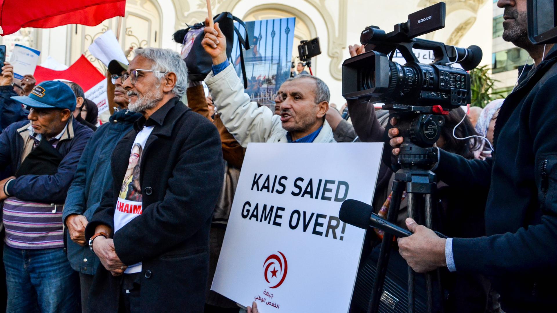 Demonstration gegen Kais Saied. Ein Demonstrant hält ein Schild mit der Aufschrift "Kais Saied Game Over" hoch. Demonstration gegen Kais Saied. Ein Demonstrant hält ein Schild mit der Aufschrift "Kais Saied Game Over" hoch.