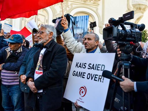 Demonstration gegen Kais Saied. Ein Demonstrant hält ein Schild mit der Aufschrift "Kais Saied Game Over" hoch.