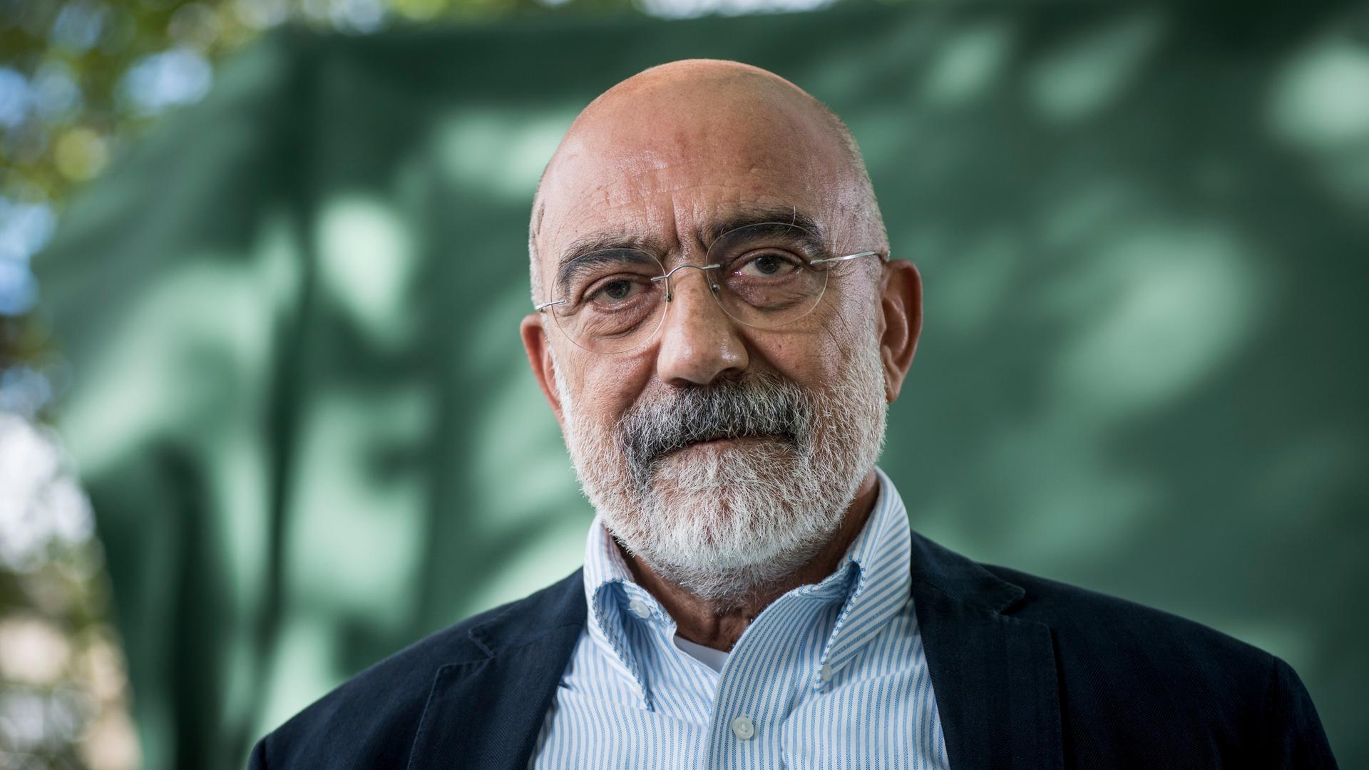 Porträt des türkischen Journalisten und Autors Ahmet Altan. Altan trägt Glatze, grauen Bart, eine randlose Brille, ein gestreiftes Hemd und ein blaues Jacket. Der Hintergrund ist grün. Porträt des türkischen Journalisten und Autors Ahmet Altan. Altan trägt Glatze, grauen Bart, eine randlose Brille, ein gestreiftes Hemd und ein blaues Jacket. Der Hintergrund ist grün.