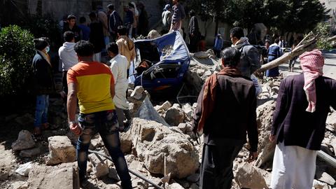 Viele arabisch gekleidete Leute laufen durcheinander nachdem ein Wohngebiet von einem Luftangriff getroffen wurde. 
