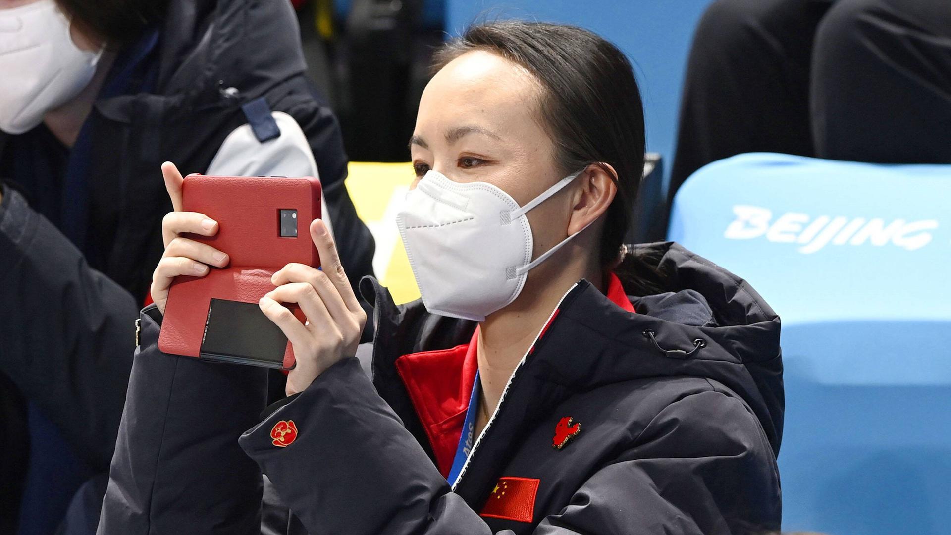 Peng Shuai fotografiert bei einem olympischen Eiskunstlauf-Wettkampf in Peking mit ihrer Handykamera. 