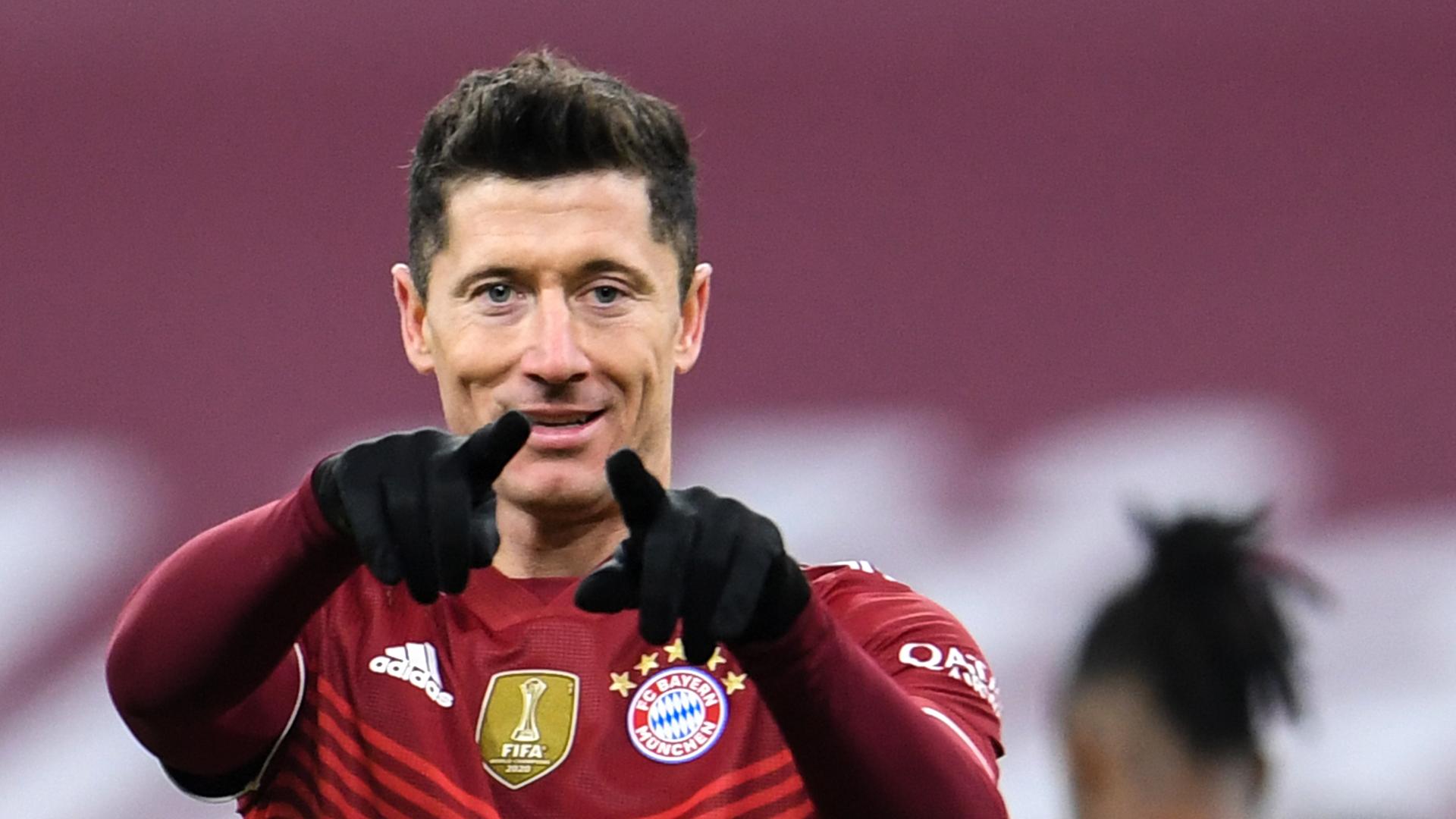 Der Fußballer Robert Lewandowski trägt ein Trikot des FC Bayern München und jubelt in die Kamera. Der Fußballer Robert Lewandowski trägt ein Trikot des FC Bayern München und jubelt in die Kamera.