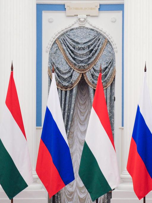 Ungarns Premierminister Vikor Orbán und Russlands Präsident Wladimir Putin geben eine Pressekonferenz, im Hintergrund die Flaggen Russlands und der Ukraine