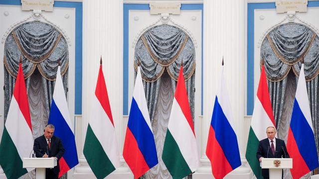 Ungarns Premierminister Vikor Orbán und Russlands Präsident Wladimir Putin geben eine Pressekonferenz, im Hintergrund die Flaggen Russlands und der Ukraine