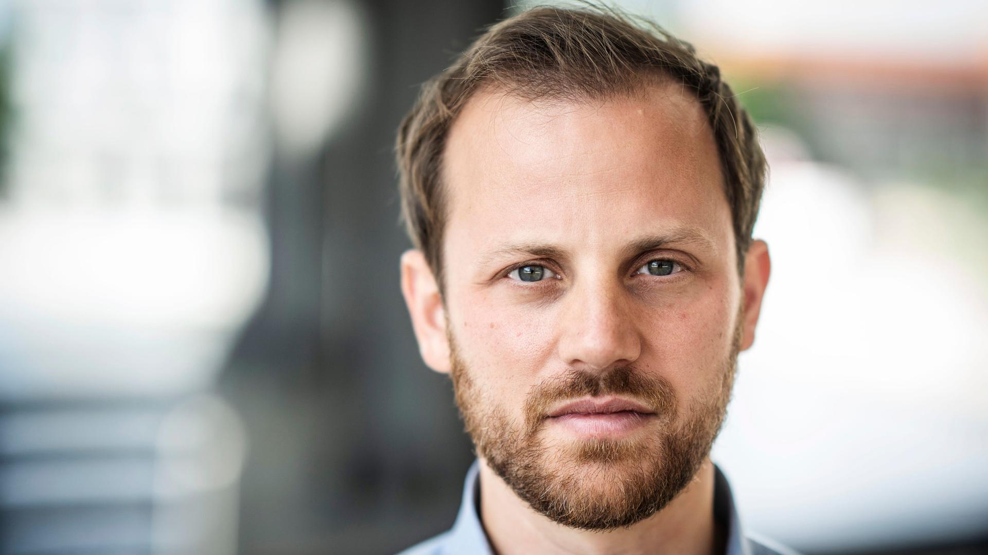 Jonas Schaible trägt ein hellblaues Hemd und blickt ernst in die Kamera. Jonas Schaible trägt ein hellblaues Hemd und blickt ernst in die Kamera.