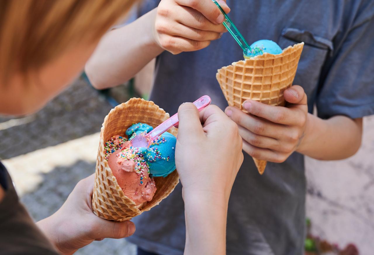 Kinder essen bunte Kugeln Eis mit unterschiedlichen Geschmacksrichtungen Kinder essen bunte Kugeln Eis mit unterschiedlichen Geschmacksrichtungen