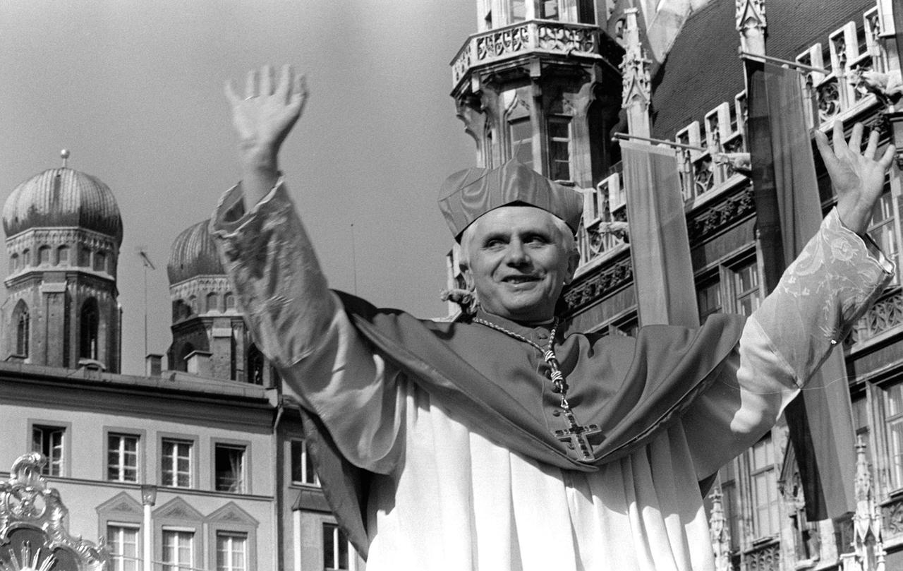 Kardinal Joseph Ratzinger hebt beide Arme zum Gruß, im Hintergrund die Türme des Münchener Doms Liebfrauenkirche Kardinal Joseph Ratzinger hebt beide Arme zum Gruß, im Hintergrund die Türme des Münchener Doms Liebfrauenkirche