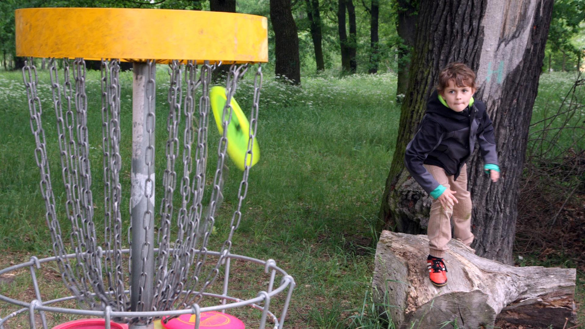 Ein Kind spielt in einem Park in Potsdam Discgolf. Ein Kind spielt in einem Park in Potsdam Discgolf.