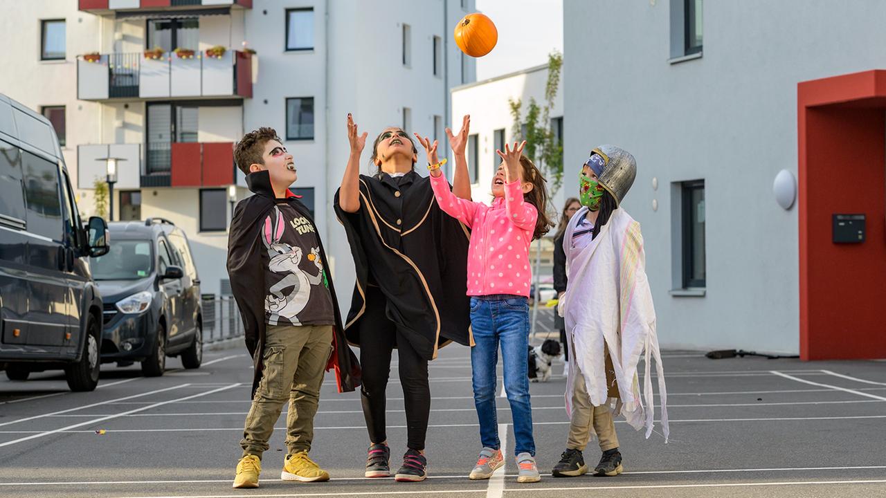 Kinder feiern verkleidet auf der Straße des neun Wohngebiets "ToM Tolerantes Miteinander" Halloween. 
