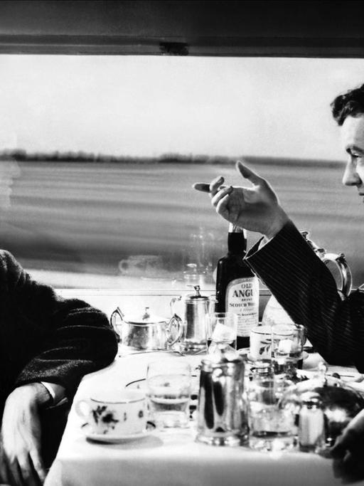 Auf einer Zugreise lernt Guy Haines einen Mann kennen, der ihm einen unglaublichen Handel vorschlägt. . Ausschnitt aus dem Film von Alfred Hitchcock aus dem Jahr 1951 mit den Schauspielern Farley Granger & Robert Walker. Zu sehen: Eine Szene in einem Speisewagen. 