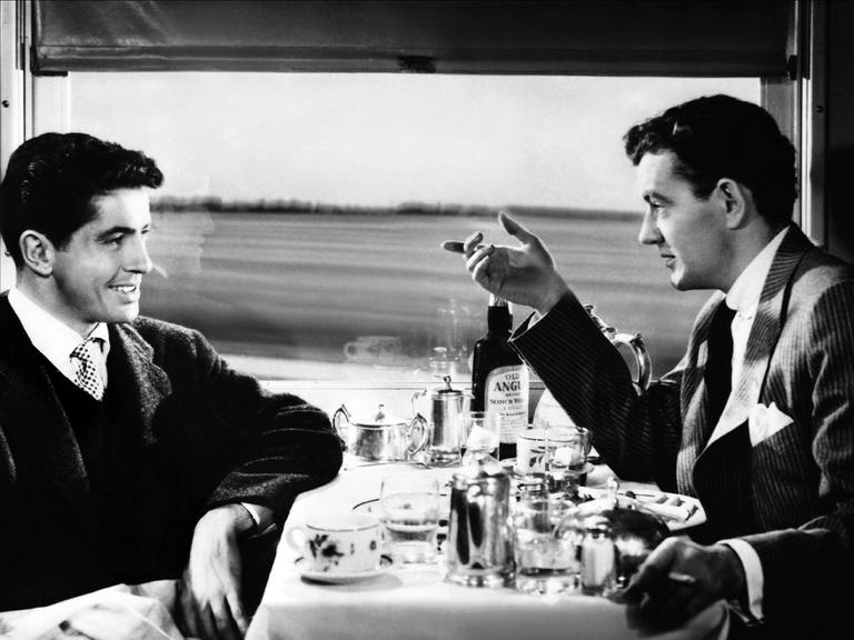 Auf einer Zugreise lernt Guy Haines einen Mann kennen, der ihm einen unglaublichen Handel vorschlägt. . Ausschnitt aus dem Film von Alfred Hitchcock aus dem Jahr 1951 mit den Schauspielern Farley Granger & Robert Walker. Zu sehen: Eine Szene in einem Speisewagen. 