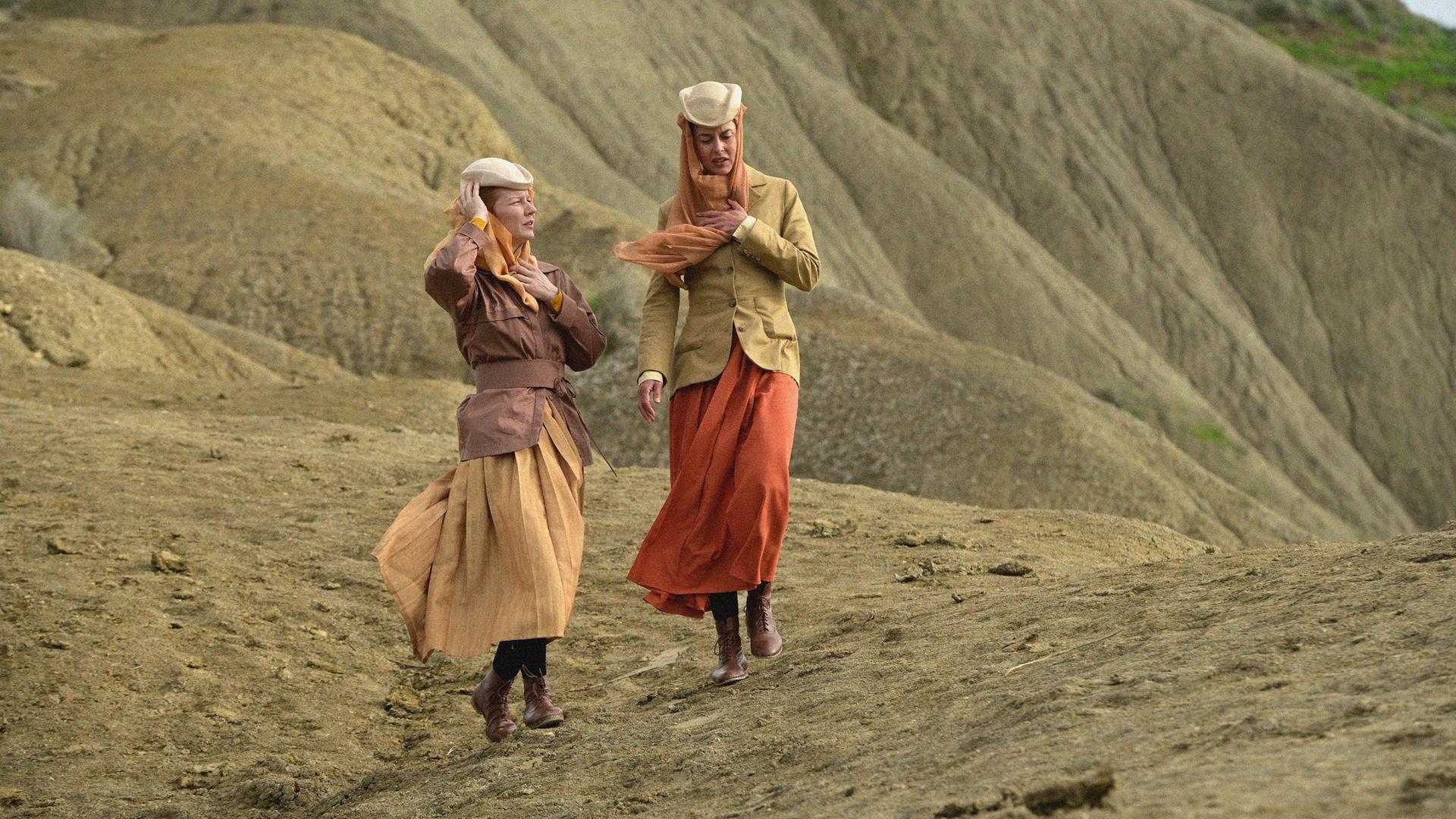 Die Schauspielerinnen Susanne Wolf (rechts) und Sandra Hüller in der Filmproduktion: "Sisi und ich": Zwei elegant gekleidete Frauen laufen durch ein Dünenlandschaft. Die Schauspielerinnen Susanne Wolf (rechts) und Sandra Hüller in der Filmproduktion: "Sisi und ich": Zwei elegant gekleidete Frauen laufen durch ein Dünenlandschaft.