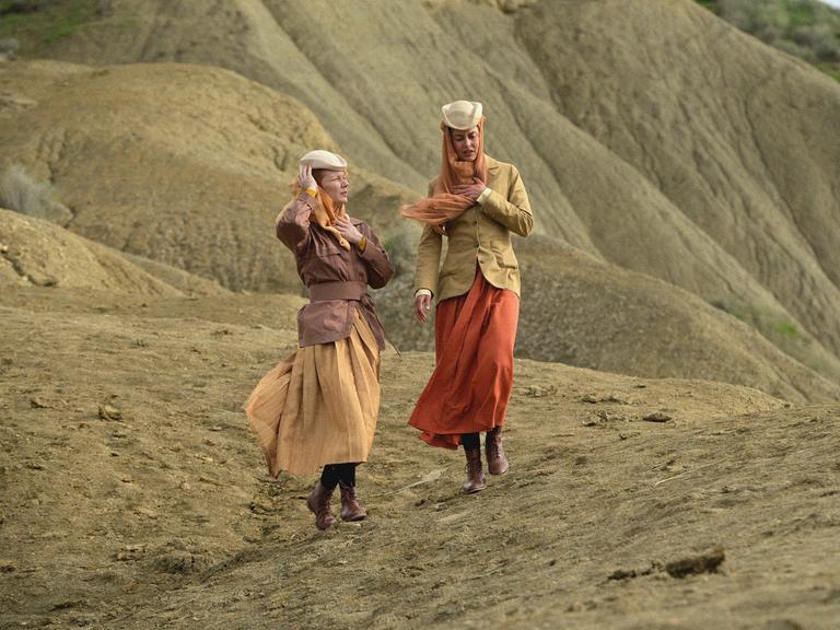 Die Schauspielerinnen Susanne Wolf (rechts) und Sandra Hüller in der Filmproduktion: "Sisi und ich":  Zwei elegant gekleidete Frauen laufen durch ein Dünenlandschaft.