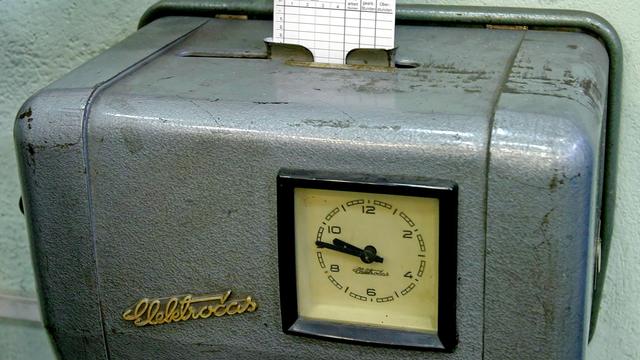 Die Hand eines Facharbeiters der Magdeburger Werkzeugmaschinen AG steckt eine Stempelkarte in eine Stechuhr (aufgenommen am 01.04.2004)