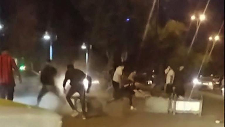 Auf einem unscharfen Bild sind Menschen zu sehen, die bei Protesten in der westiranischen Stadt Bukan bei Dunkelheit auf der Straße vor staatlichen Sicherheitskräften weglaufen. Auf einem unscharfen Bild sind Menschen zu sehen, die bei Protesten in der westiranischen Stadt Bukan bei Dunkelheit auf der Straße vor staatlichen Sicherheitskräften weglaufen.