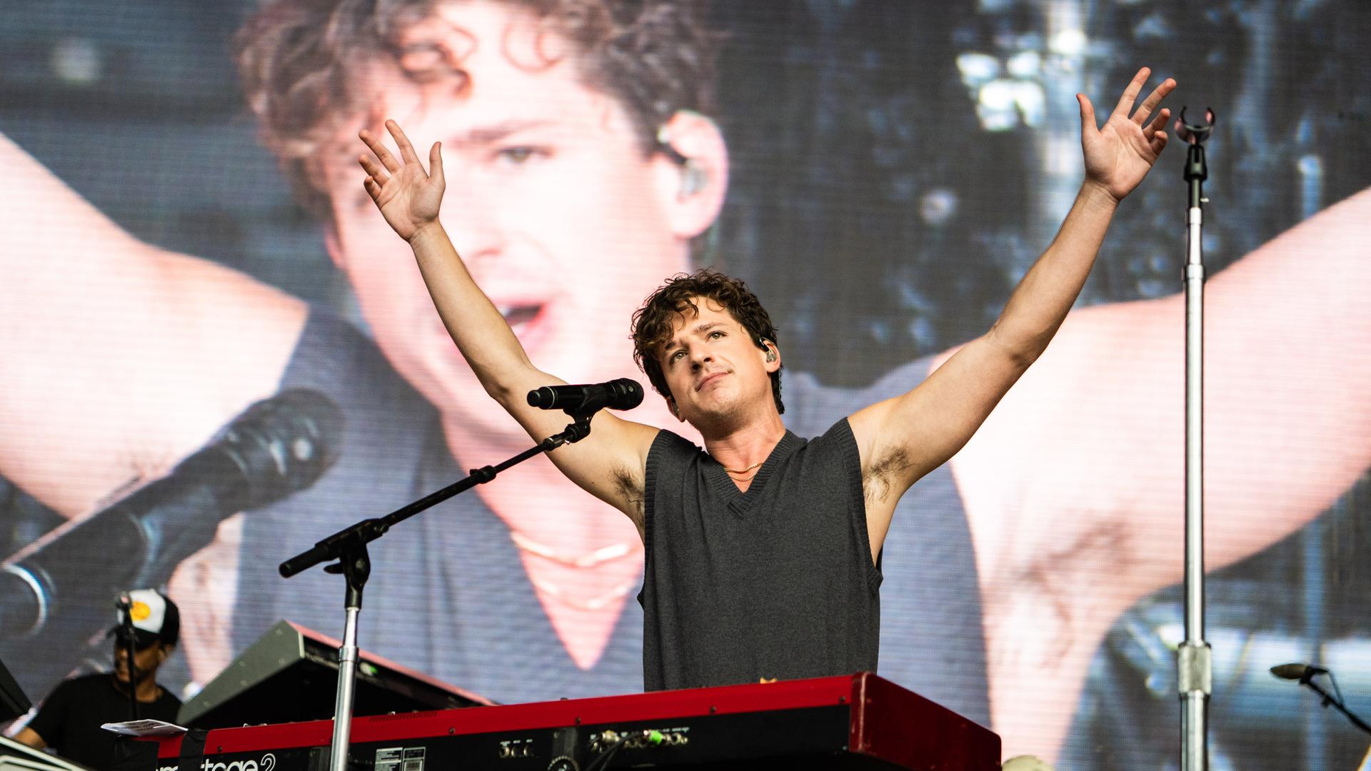 Charlie Puth steht beim Sommerkonzert "Wild 94.9 WAZZMATAZZ 2022" in Kalifornien in den USA hinter seinem Keyboard und reckt beide Arme in die Höhe. Hinter ihm ist sein Gesicht auf einem Monitor zu sehen. Charlie Puth steht beim Sommerkonzert "Wild 94.9 WAZZMATAZZ 2022" in Kalifornien in den USA hinter seinem Keyboard und reckt beide Arme in die Höhe. Hinter ihm ist sein Gesicht auf einem Monitor zu sehen.