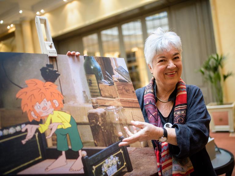 Barbara von Johnson, Illustratorin und Gestalterin des visuellen Erscheinungsbildes von Pumuckl, mit einem Bild des Kobolds.