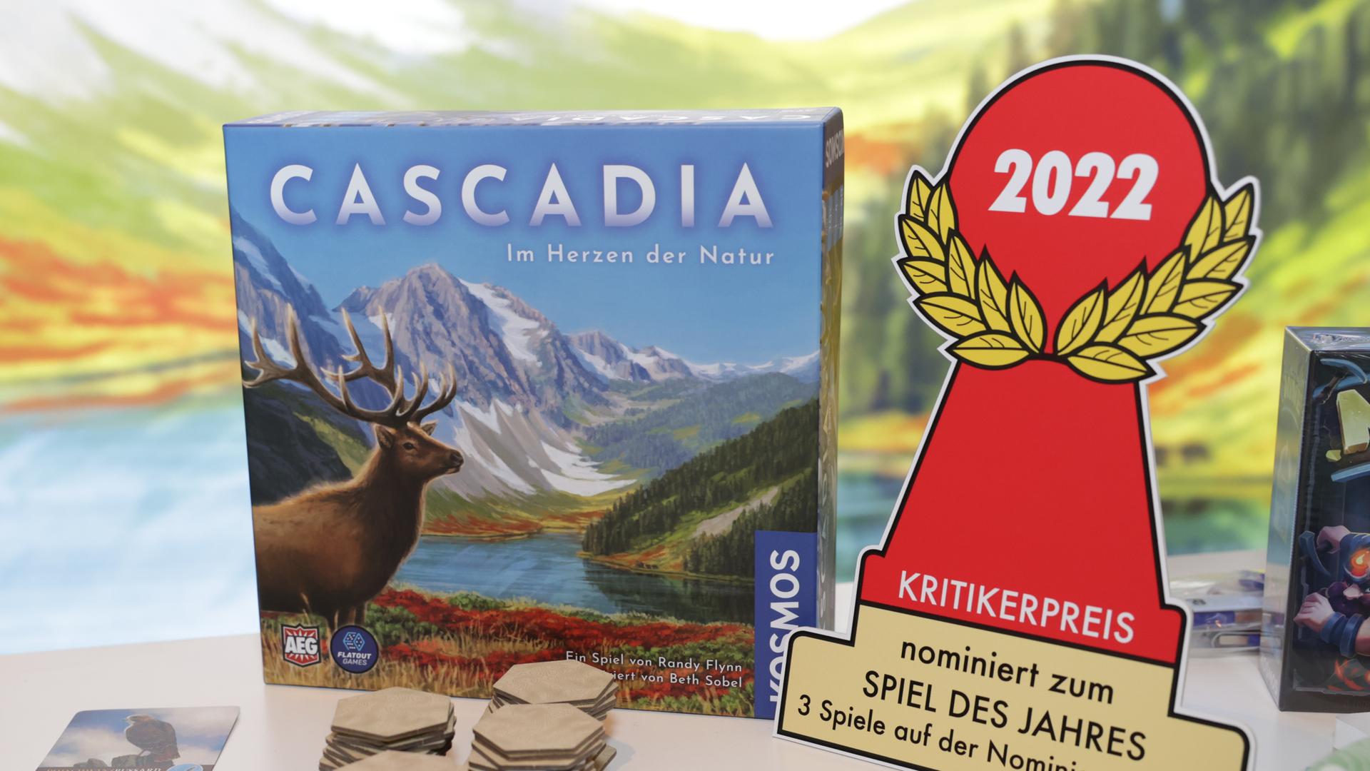Auf einem Tisch steht das Spiel "Cascadia. Es ist das "Spiel des Jahres". Auf einem Tisch steht das Spiel "Cascadia. Es ist das "Spiel des Jahres".