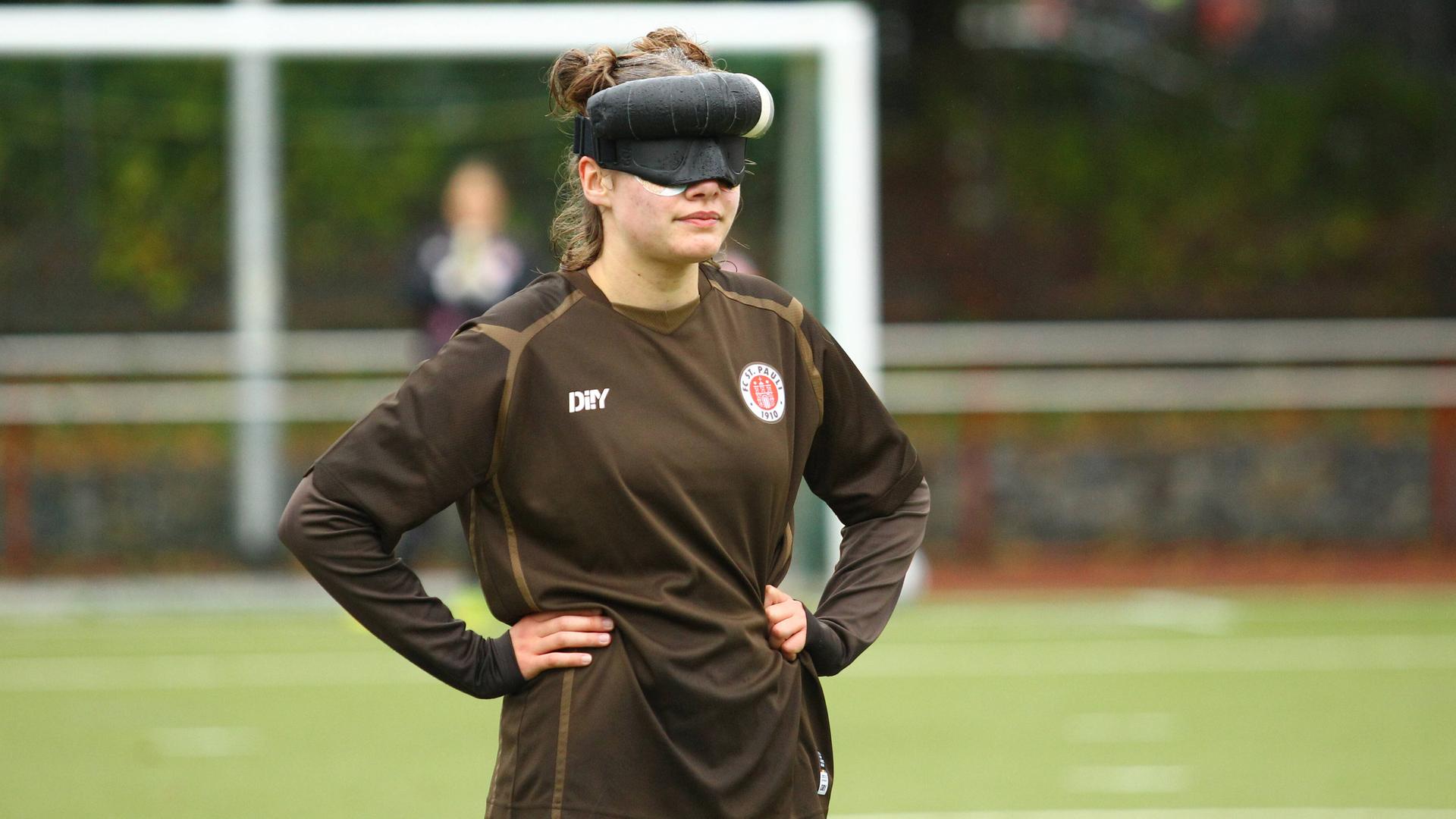 Blindenfußballerin Thoya Küster während eines Spiels für den FC St. Pauli mit Sichtschutz vor den Augen. Ihre Hände hat sie in die Hüften gestemmt. Blindenfußballerin Thoya Küster während eines Spiels für den FC St. Pauli mit Sichtschutz vor den Augen. Ihre Hände hat sie in die Hüften gestemmt.