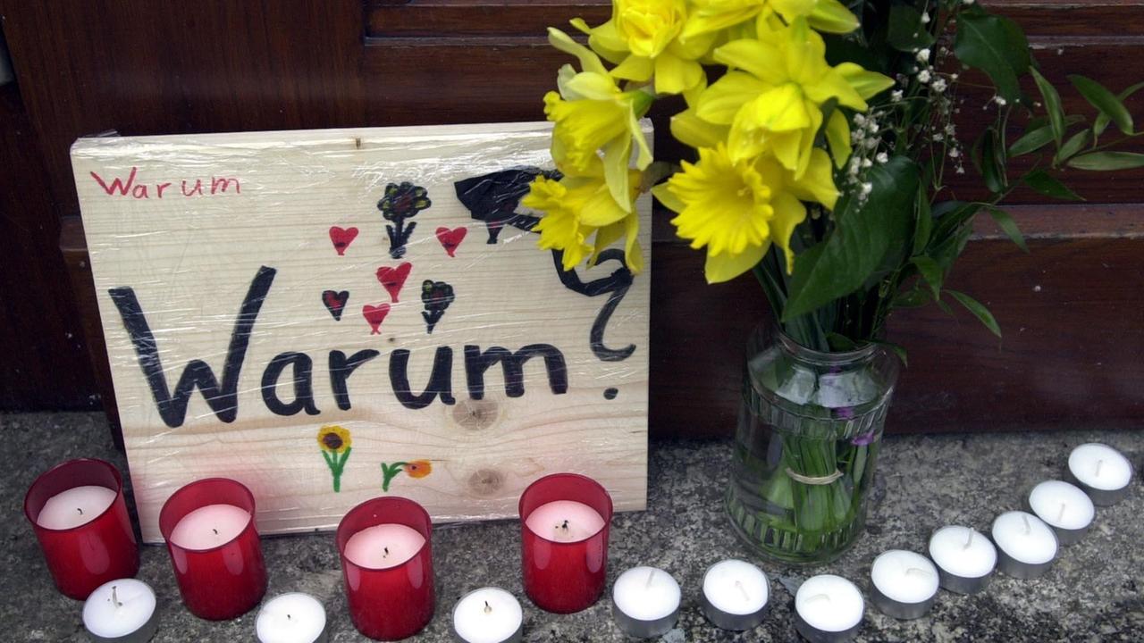 Blumen, Kerzen und ein Schild mit der Aufschrift "Warum?" stehen am 26.04.2002 in Erfurt an einem Eingang des Gutenberg-Gymnasiums in Erfurt. In einem entsetzlichen Amoklauf hatte ein ehemaliger Schüler in diesem Gymnasium 16 Menschen und sich selbst erschossen. Blumen, Kerzen und ein Schild mit der Aufschrift "Warum?" stehen am 26.04.2002 in Erfurt an einem Eingang des Gutenberg-Gymnasiums in Erfurt. In einem entsetzlichen Amoklauf hatte ein ehemaliger Schüler in diesem Gymnasium 16 Menschen und sich selbst erschossen.