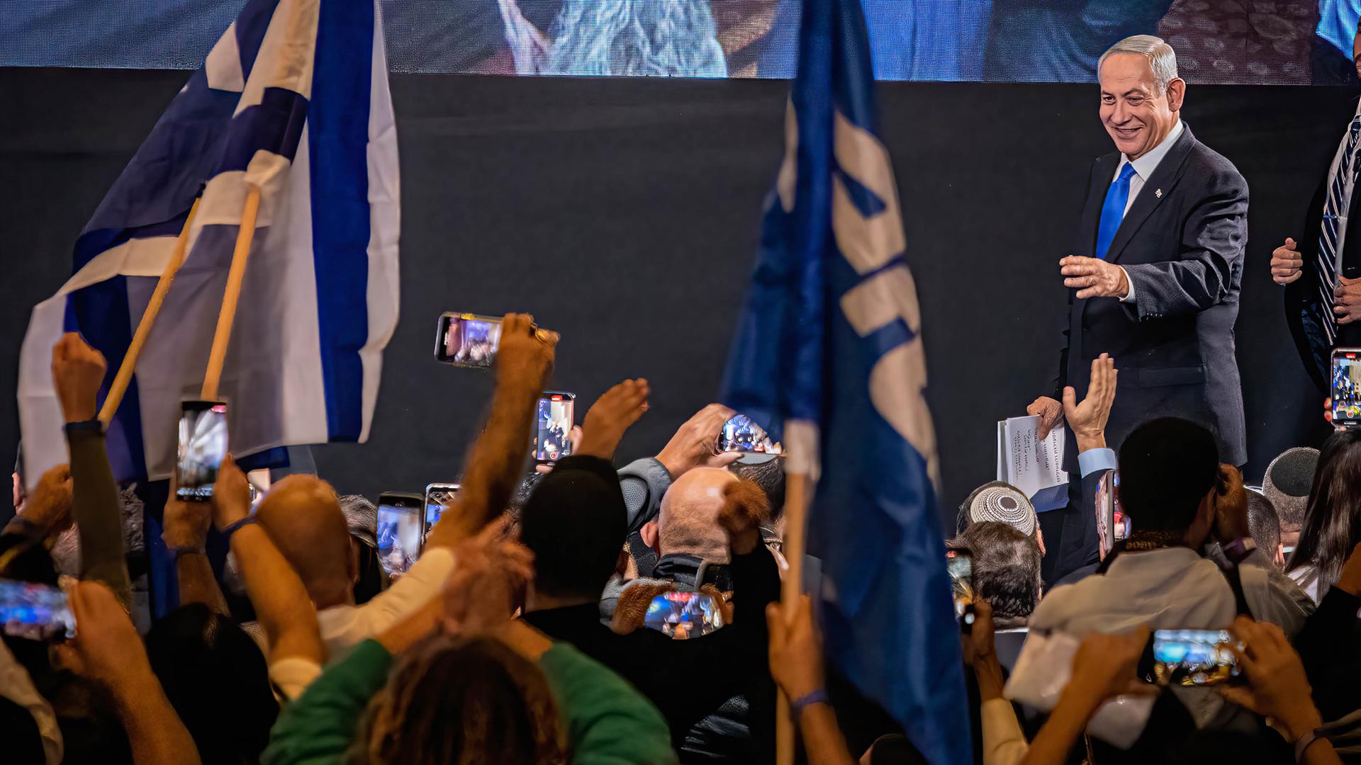 Benjamin Netanyahu auf einer Wahlbühne mit Unterstützern, die ihn fotografieren, November 2022.