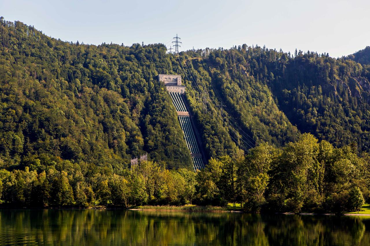 Walchensee-Wasserkraftwerk mit Druckrohrleitungen. In Bildvordergrund ist der Kochelsee zu sehen.