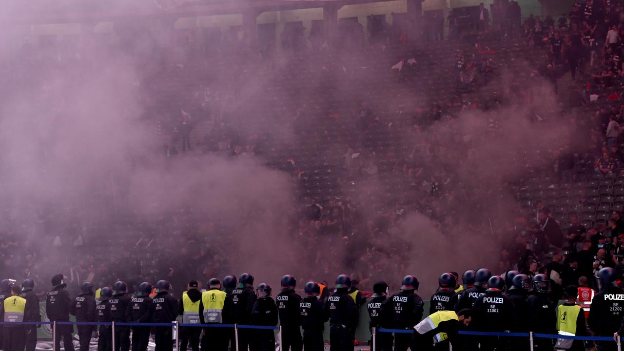 DFB-Pokalfinale: RB Leipzig - Eintracht Frankfurt. Polizisten haben vor dem Frankfurter Fanblock Aufstellung genommen. Über den Rängen liegt dichter Qualm.