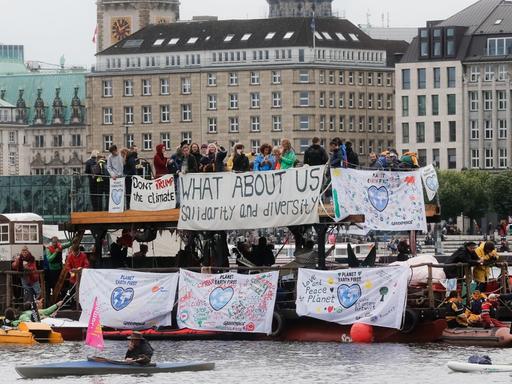 Teilnehmer der Demonstration "G20-Protestwelle" fahren in Hamburg mit einem Floß auf der Binnenalster.
