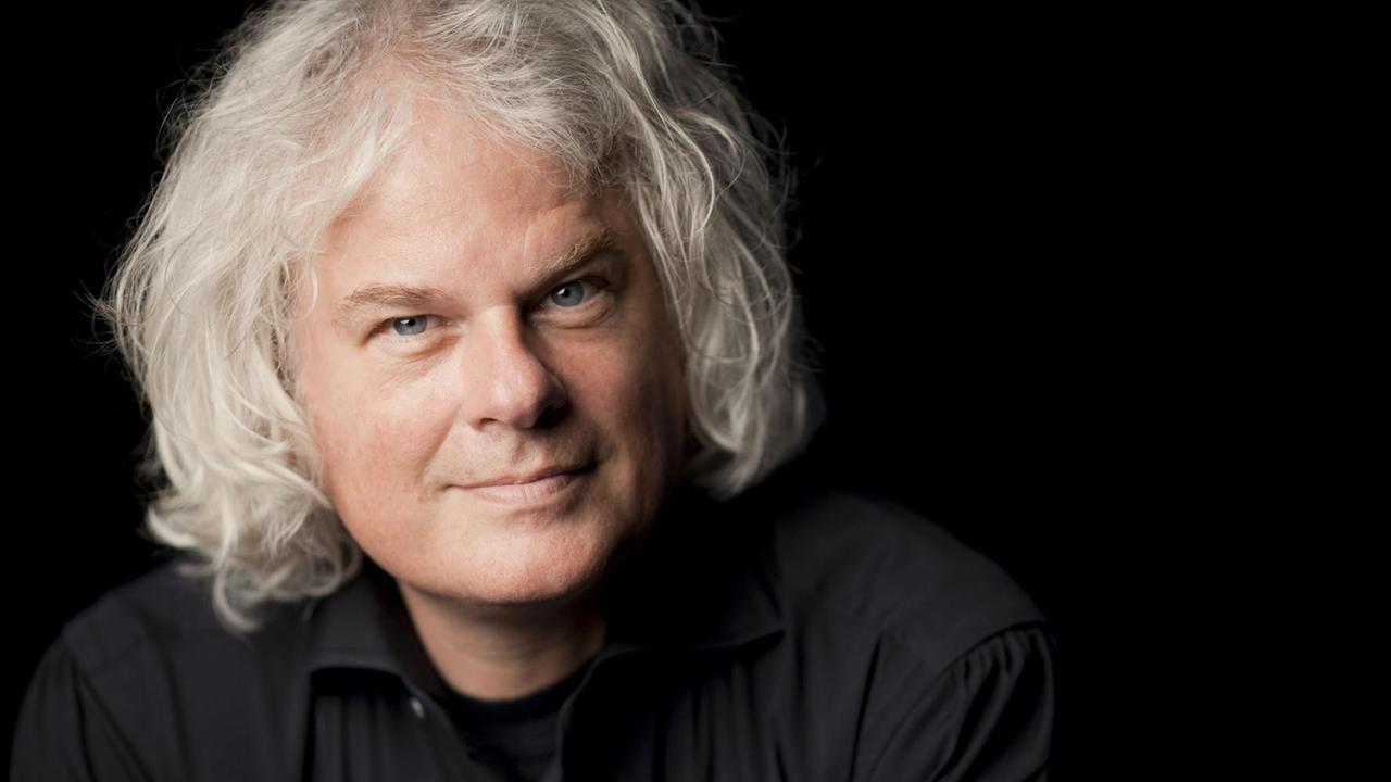Ronald Brautigam blickt lächelnd in die Kamera, während seine grauen Locken seinen Kopf umgeben. Ronald Brautigam blickt lächelnd in die Kamera, während seine grauen Locken seinen Kopf umgeben.