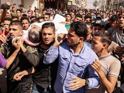 Ein Trauerzug mit dem Körper von Majd Abu Saadahthe, getragen auf den Armen von vielen Männern. Der Palästinenser kam durch einen israelischen Angriff ums Leben. Im Gazastreifen, 12. Mai 2021.