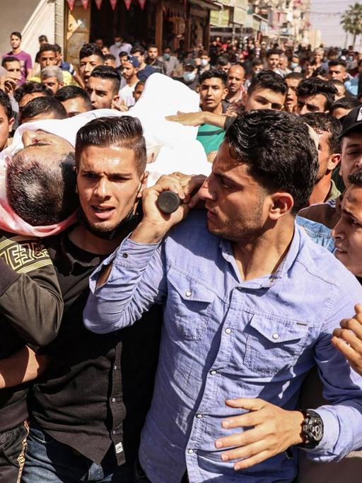 Ein Trauerzug mit dem Körper von Majd Abu Saadahthe, getragen auf den Armen von vielen Männern. Der Palästinenser kam durch einen israelischen Angriff ums Leben. Im Gazastreifen, 12. Mai 2021.