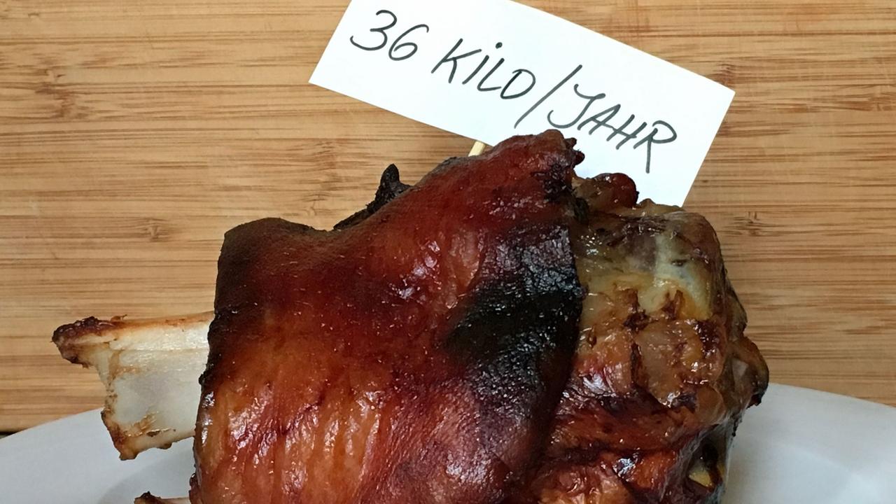 Eine Schweinshaxe mit einem Schild 36 Kilo pro Jahr. Eine Schweinshaxe mit einem Schild 36 Kilo pro Jahr.