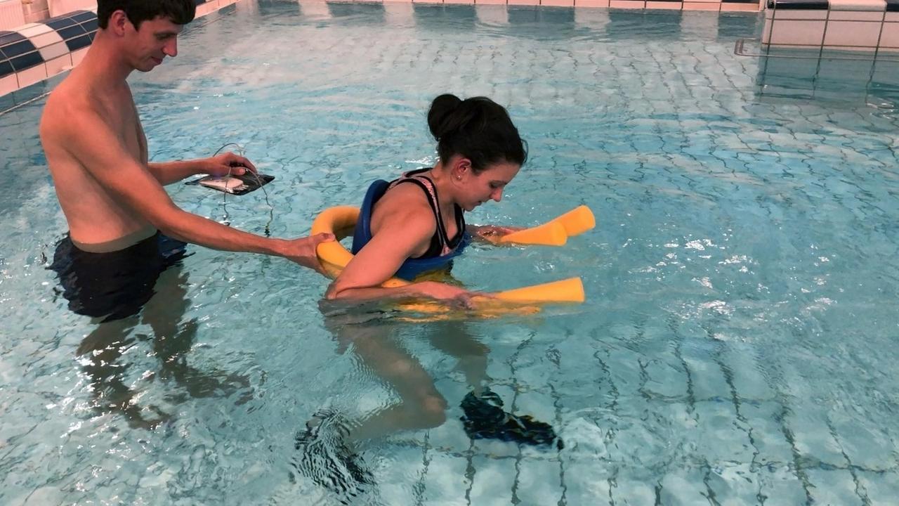 Ein Mann führt eine junge Frau durch hüfthohes Wasser. Ein Mann führt eine junge Frau durch hüfthohes Wasser.