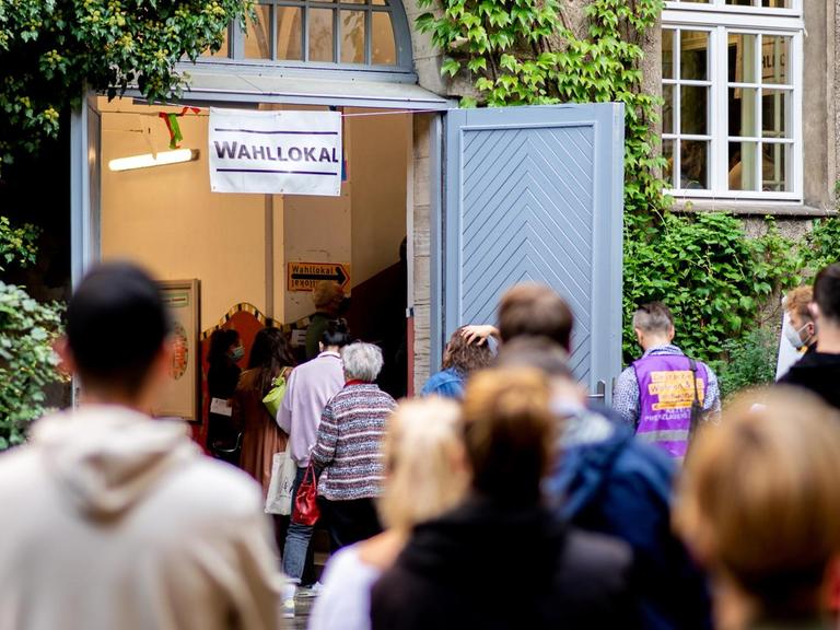 Zahlreiche Wählerinnen und Wähler warten im Stadtteil Prenzlauer Berg in einer langen Schlange vor einem Wahllokal, das in einer Grundschule untergebracht ist.