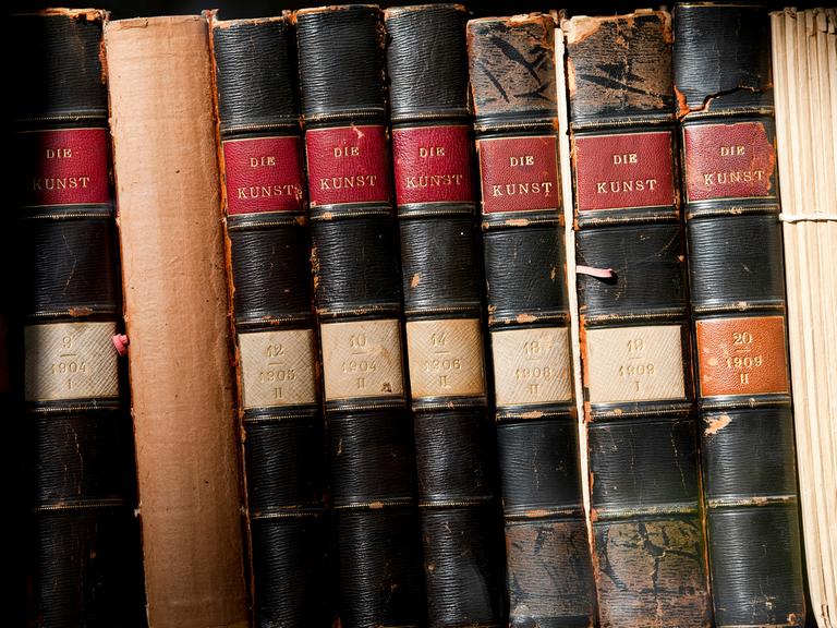 Antiquarische Bücher mit dem Titel "Die Kunst" stehen im Regal eines Antiquariats.
