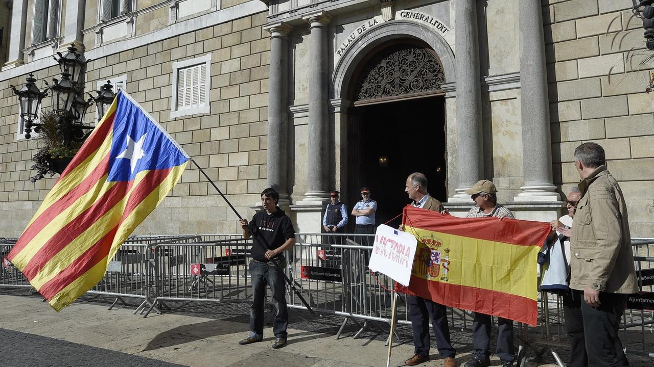 Vor dem Sitz der katalanischen Regionalregierung in Barcelona, der "Generalitat", werden am 30.10.17 die katalanische und die spanische Flagge geschwenkt. 