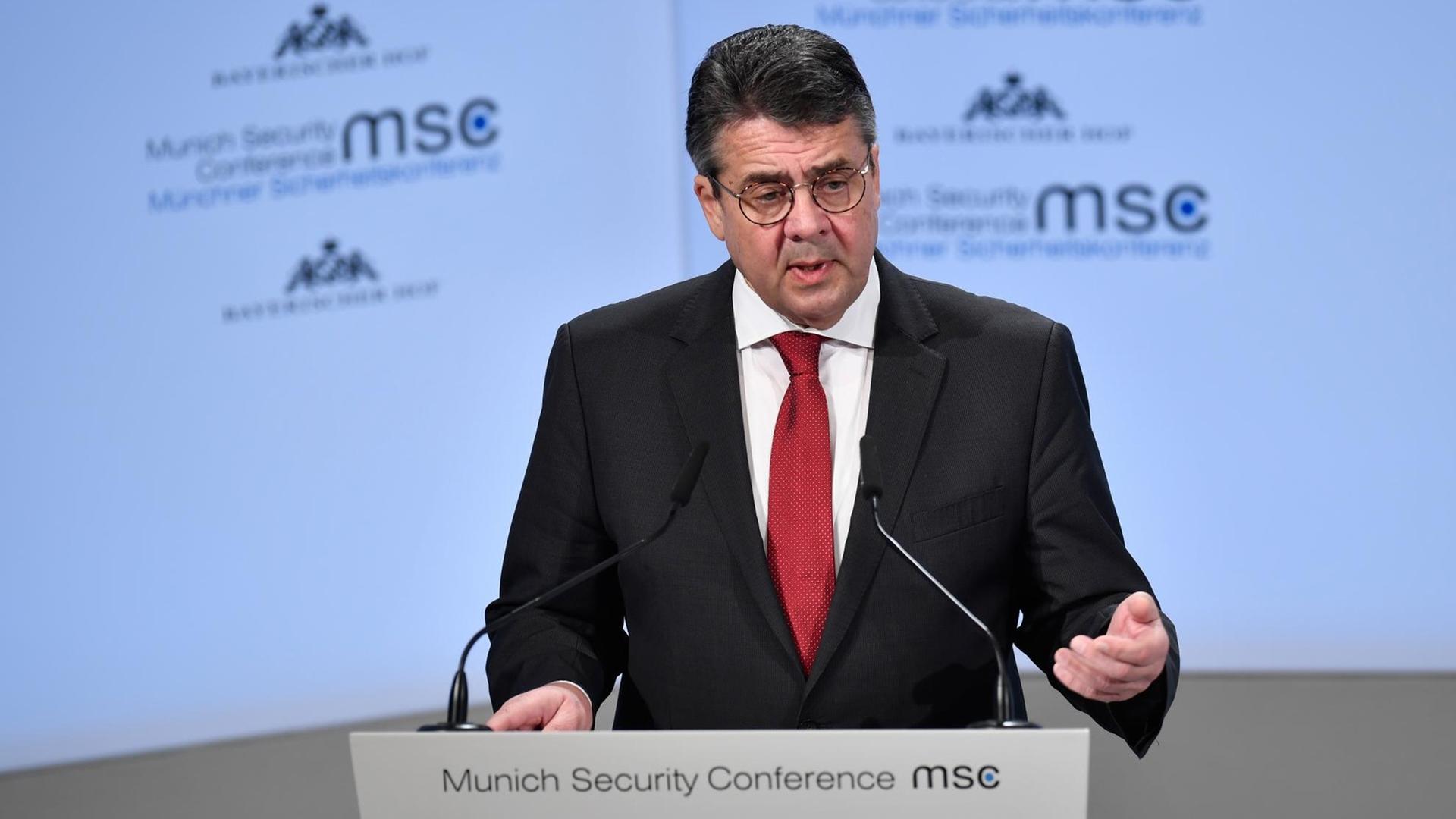 Bundesaußenminister Gabriel bei seiner Rede auf der Münchner Sicherheitskonferenz 2018. Er steht an einen Pult mit Mikrophonen, dahinter eine Wand mit Logos der Konferenz. Bundesaußenminister Gabriel bei seiner Rede auf der Münchner Sicherheitskonferenz 2018. Er steht an einen Pult mit Mikrophonen, dahinter eine Wand mit Logos der Konferenz.