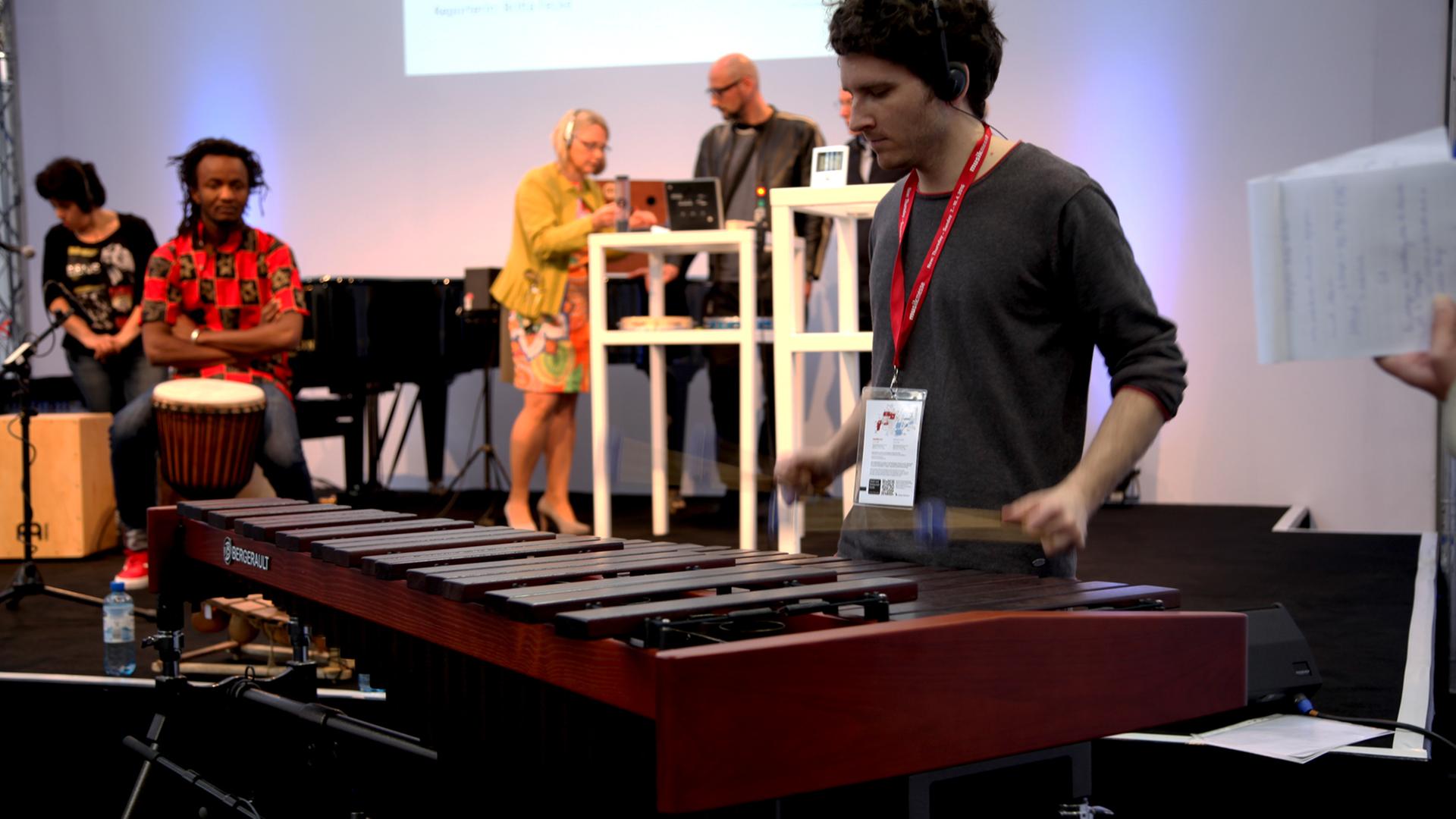 Ein Musiker spielt mit Schlägeln auf der Marimba Ein Musiker spielt mit Schlägeln auf der Marimba