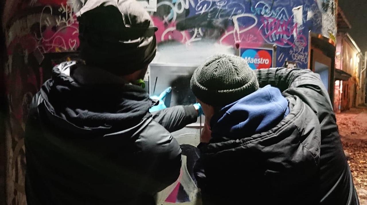Zwei Personen stehen vor einer Mauer. Zwei Personen stehen vor einer Mauer.