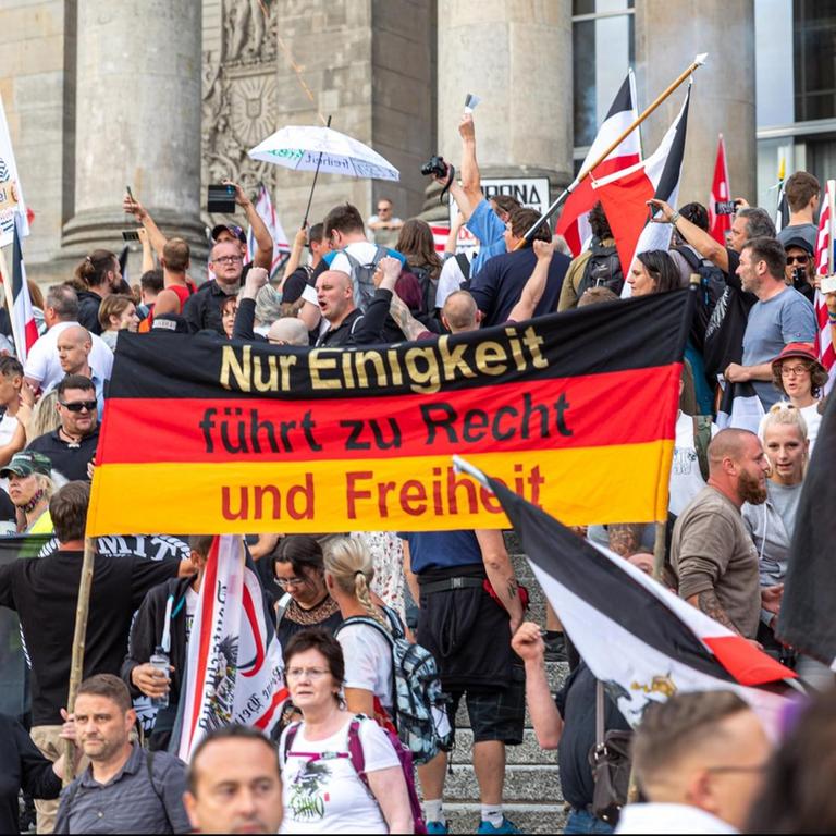 Rechtsextreme schwenken Reichsflaggen vor dem Reichstagsgebäude in Berlin