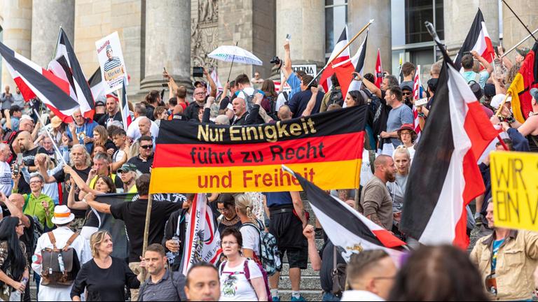 Rechtsextreme schwenken Reichsflaggen vor dem Reichstagsgebäude in Berlin