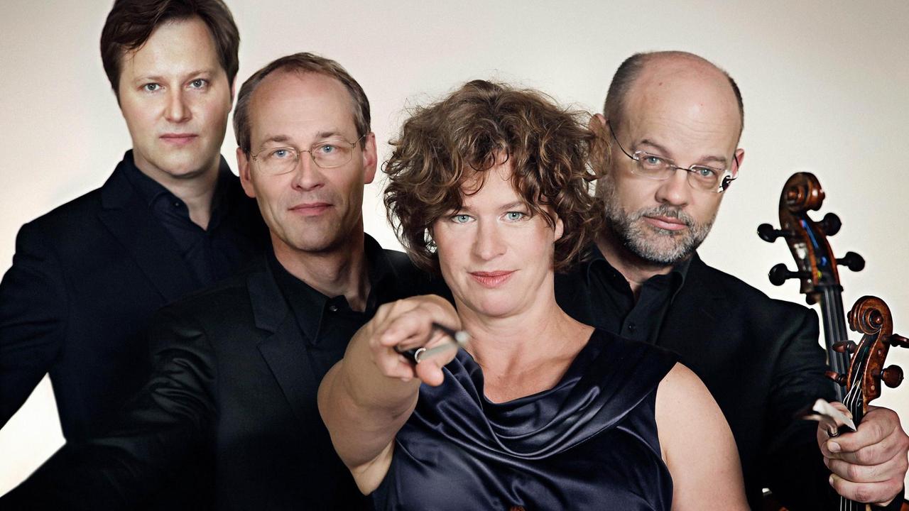 Die Geigerin des Quartetts scheint mit dem Bogen Richtung Kamera zu zielen. Die Geigerin des Quartetts scheint mit dem Bogen Richtung Kamera zu zielen.