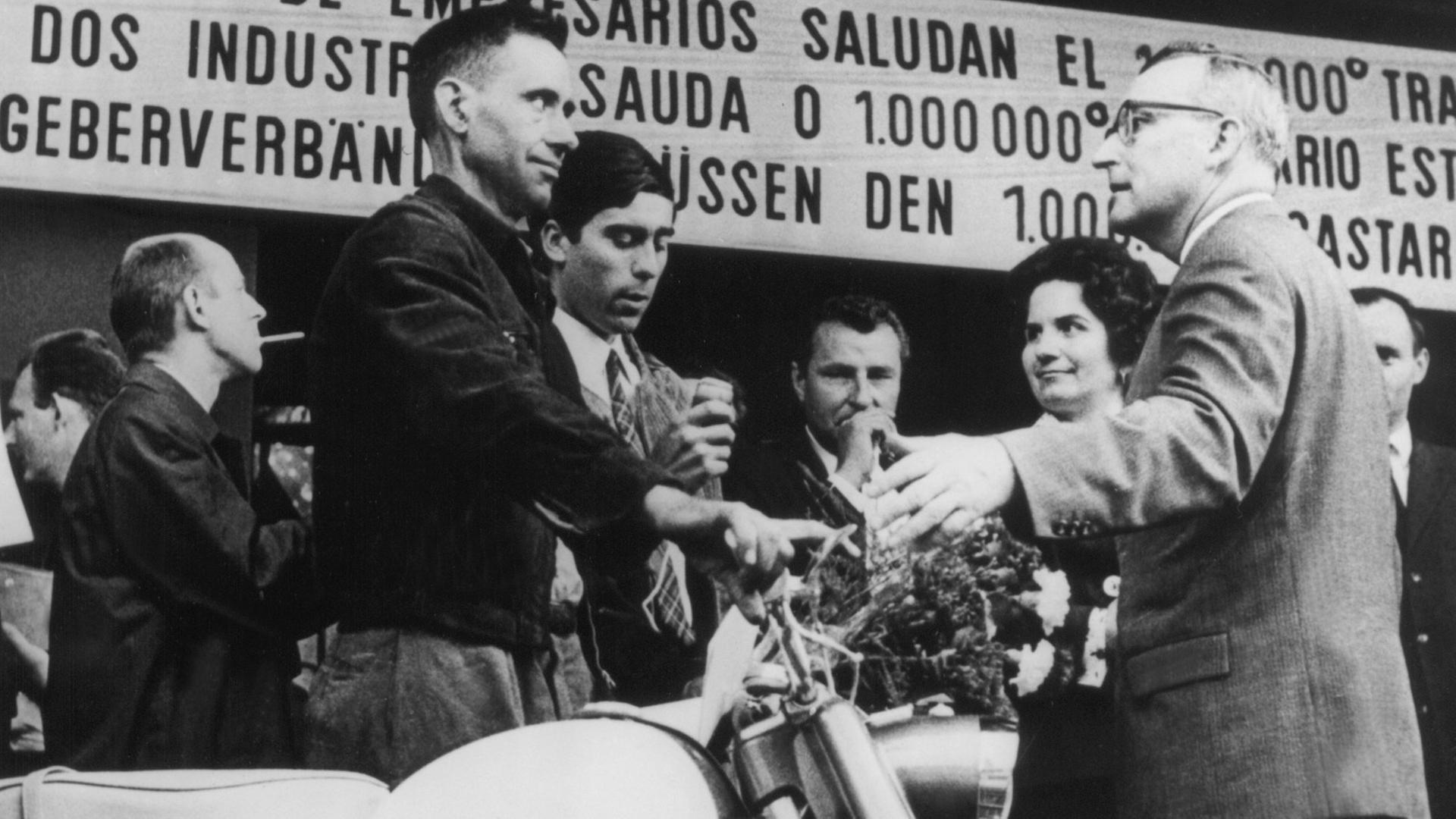 Der millionste Gastarbeiter in der Bundesrepublik, Armando Rodrigues (l.) aus Portugal, steht neben dem Moped, das er bei seiner Ankunft am 10.09.1964 im Köln-Deutzer Bahnhof geschenkt bekam. Der millionste Gastarbeiter in der Bundesrepublik, Armando Rodrigues (l.) aus Portugal, steht neben dem Moped, das er bei seiner Ankunft am 10.09.1964 im Köln-Deutzer Bahnhof geschenkt bekam.