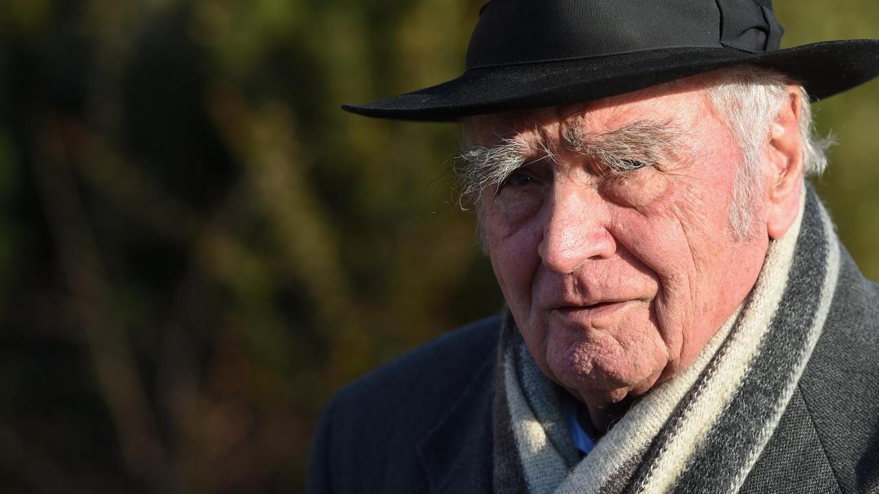Walser steht im Grünen und blickt in die Kamera. Sein schwarzer Hut ist tief in die Stirn gezogen. Walser steht im Grünen und blickt in die Kamera. Sein schwarzer Hut ist tief in die Stirn gezogen.