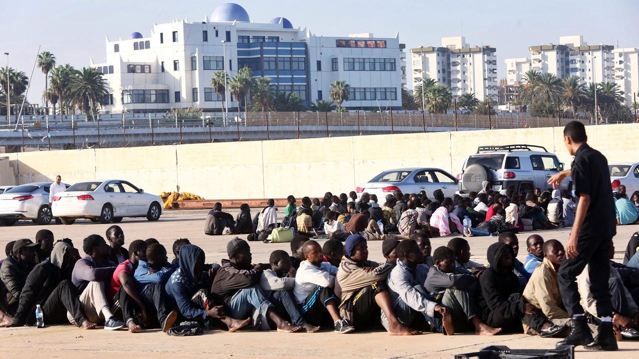 Flüchtlinge, die von der libyschen Marine festgenommen wurden, warten am 5.10.2015 in einem Dock im Hafen der Hauptstadt Libyens. Flüchtlinge, die von der libyschen Marine festgenommen wurden, warten am 5.10.2015 in einem Dock im Hafen der Hauptstadt Libyens.