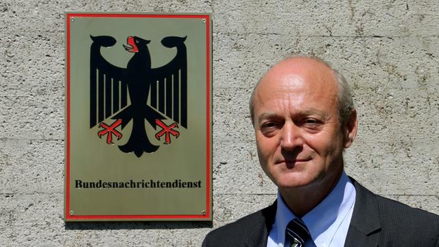 BND-Präsident Gerhard Schindler steht neben einem Schild mit Aufschrift Bundesnachrichtendienst