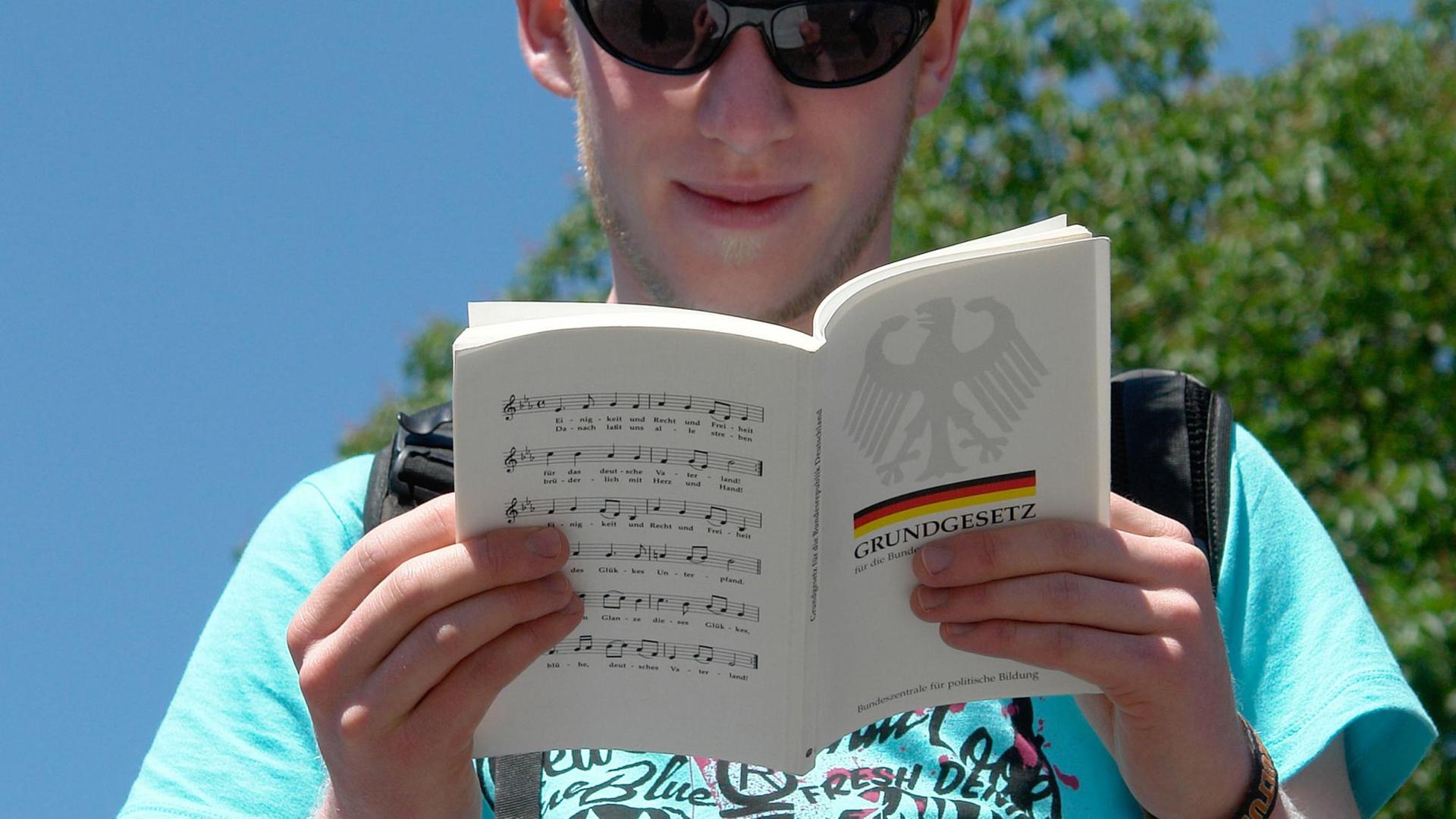 Zum 60-jährigen Jubiläum des Grundgesetzes liest in einer NRW ein Mann das Grundgesetz. Zum 60-jährigen Jubiläum des Grundgesetzes liest in einer NRW ein Mann das Grundgesetz.