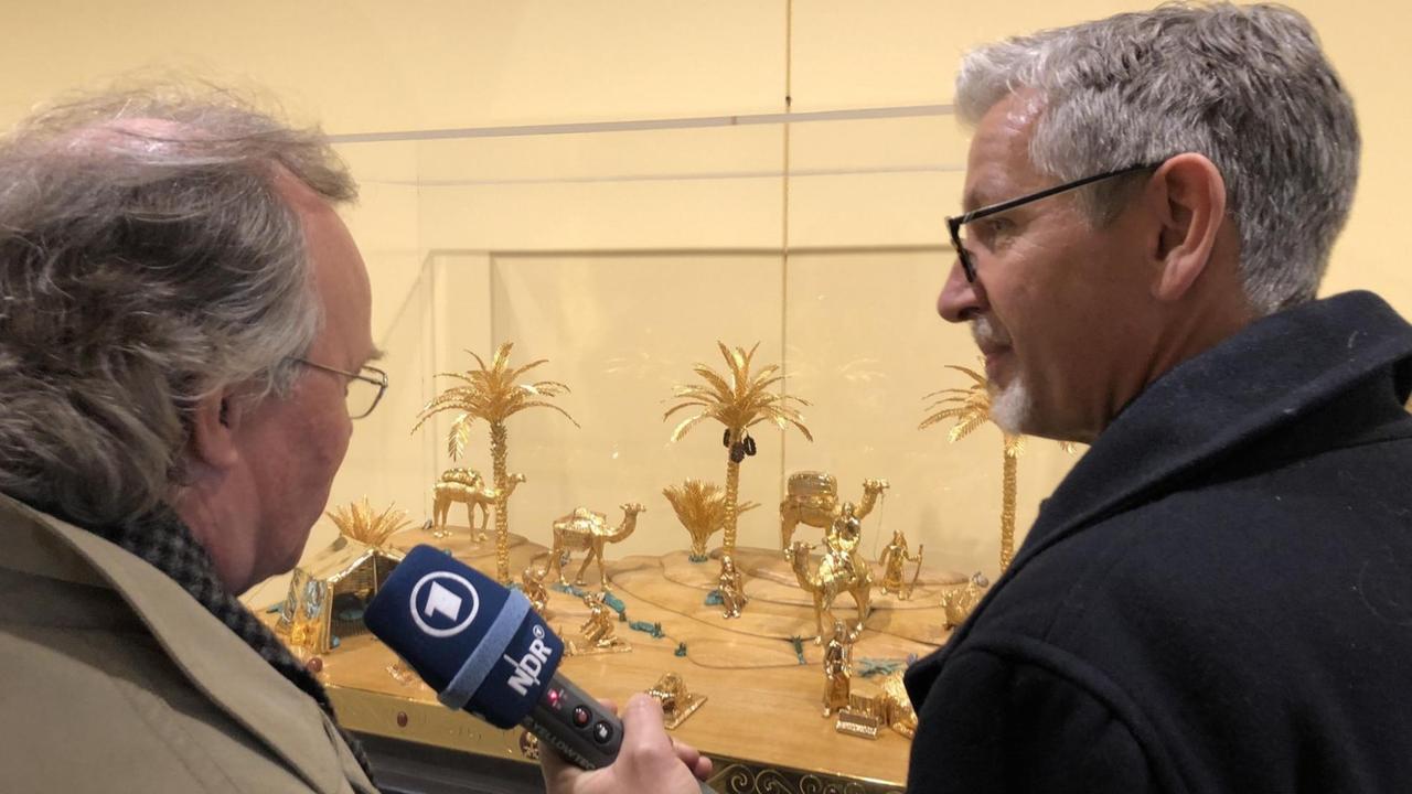 Werner Schmidt und Reporter Georg Schwarter vor dem Geschenk Saudi-Arabiens: kleine Palmen aus Gold.