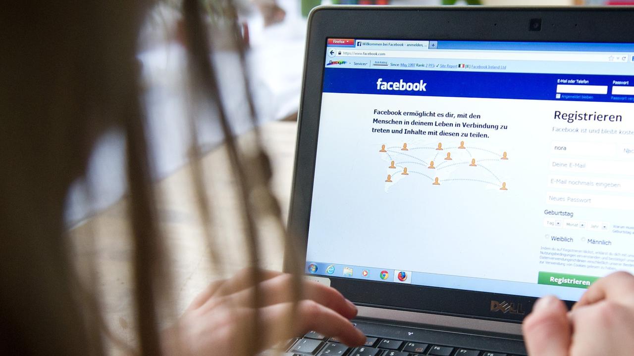 Eine Frau surft an einem Laptop auf der Seite des sozialen Netzwerks "Facebook". Eine Frau surft an einem Laptop auf der Seite des sozialen Netzwerks "Facebook".
