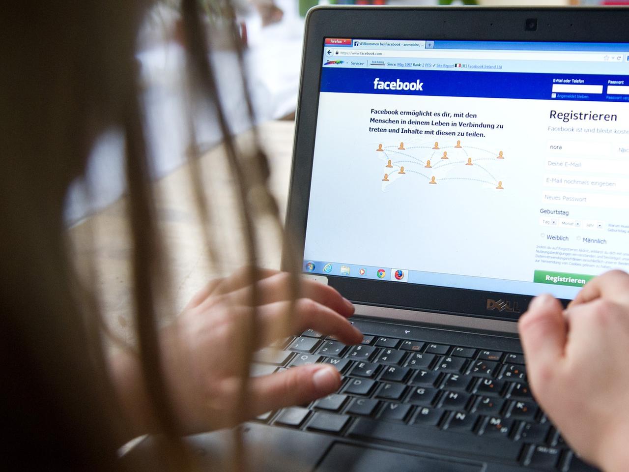Ein Kind surft an einem Laptop auf der Seite des sozialen Netzwerks "Facebook". 